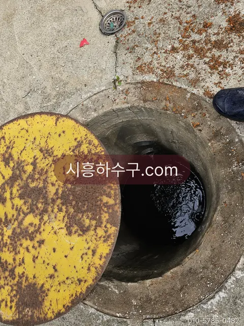 오수가 정체된 맨홀을 열어 확인하는 현장